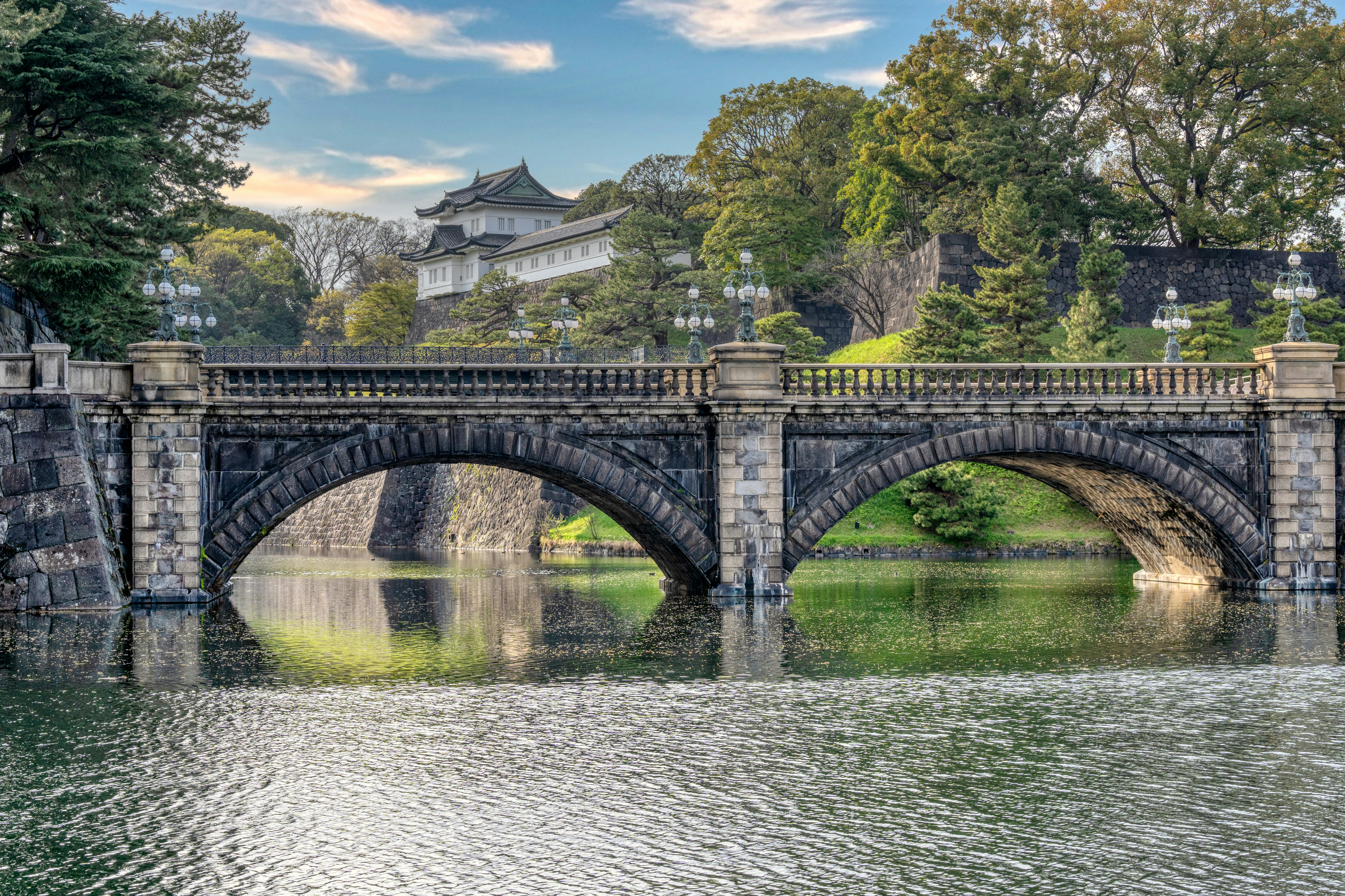 Stone walls and moat surrounding the Imperial Palace East Gardens with trees